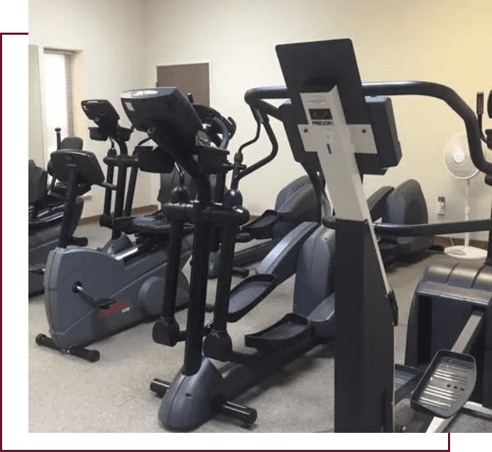 A gym with many different types of exercise equipment.