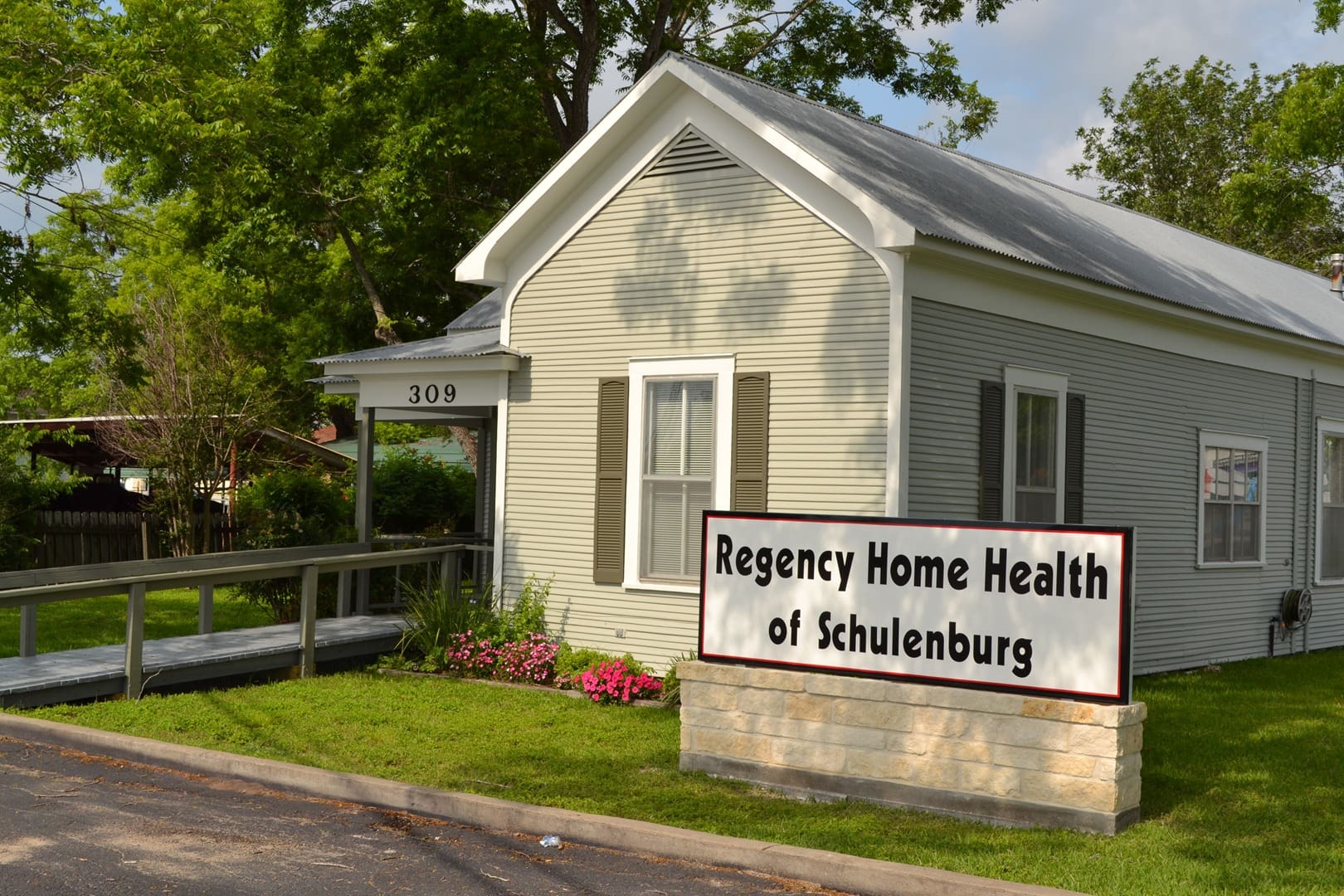 A white building with a sign on the front of it.