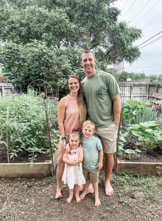 A family posing for a picture in their garden.